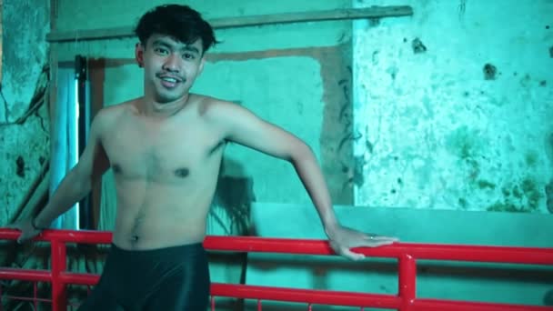 一个赤身裸体的亚洲男人站在一个有绿光的老楼里拍照时非常性感 — 图库视频影像