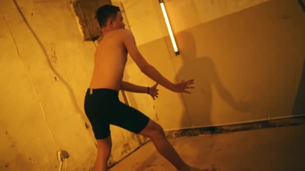 Asijský Muž Tančí Gesty Rukou Nahý Zatímco Hangáru Žlutým Světlem — Stock video