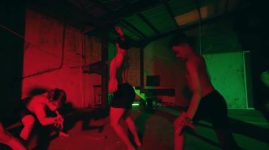 Yetenekli bir erkek dansçı, grubun merkezinde güçlü bir solo performans sergiler. Diğer dansçılar karanlık, kasvetli bir depoda, dramatik kırmızı ve yeşil ışıklı bir şekilde dolaşarak güçlü bir performans sergiliyorlar..