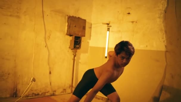 一个印度尼西亚男人在一间旧厂房的角落里跳舞 身体非常柔韧 赤身裸体 — 图库视频影像