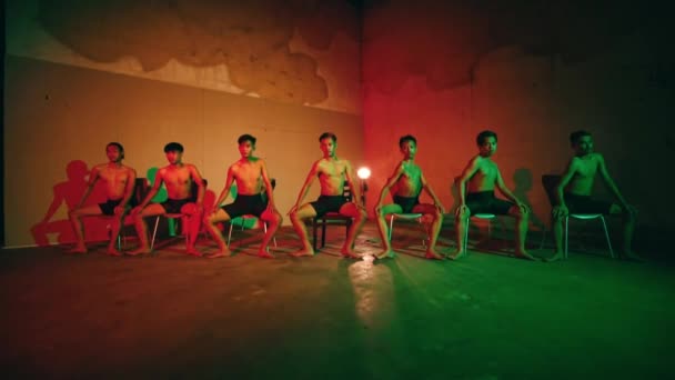 Grupo Pessoas Sentadas Cadeiras Dançando Juntas Quarto Escuro Com Uma — Vídeo de Stock