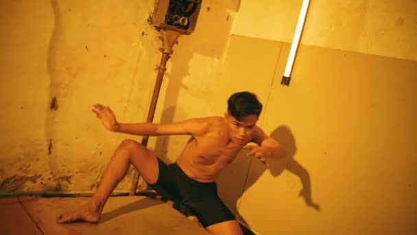 Aasialainen Mies Tanssii Mustissa Shortseissa Yksin Vanhassa Tehtaassa Iltapäivällä — kuvapankkivideo