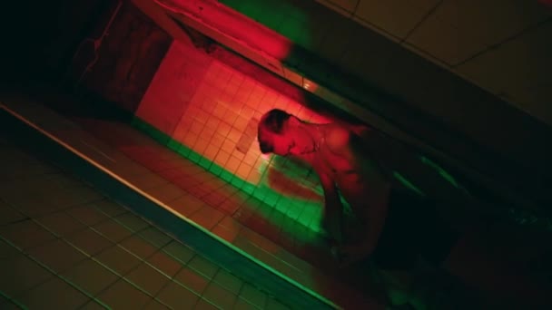 夜にネオンの暗い部屋で踊る裸の胸を持つ若者のグループ — ストック動画