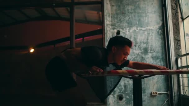 裸の胴を持つ放棄された建物で踊るセクシーアジアの男と日中椅子に座って — ストック動画