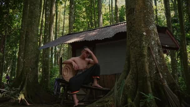 Тайский Мужчина Традиционном Костюме Сидит Скамейке Возле Беседки Джунглях Утром — стоковое видео