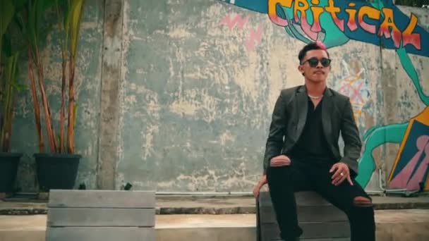 Homem Asiático Uma Jaqueta Blazer Óculos Sol Está Sentado Uma — Vídeo de Stock