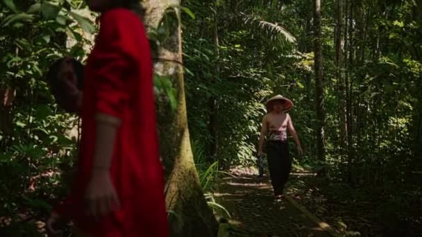 Man Halmhatt Promenader Grön Skog Passera Genom Kvinnan Röd Mantel — Stockvideo