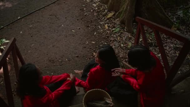 Een Groep Thaise Vrouwen Rode Jurken Zittend Houten Trap Met — Stockvideo