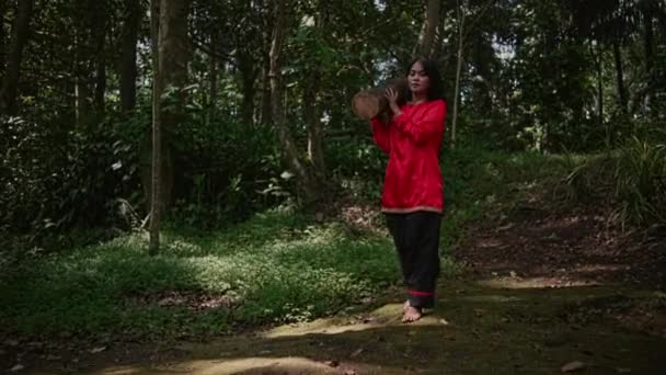 身穿红衫 肩上扛着树干的亚洲女人出现在森林里 — 图库视频影像