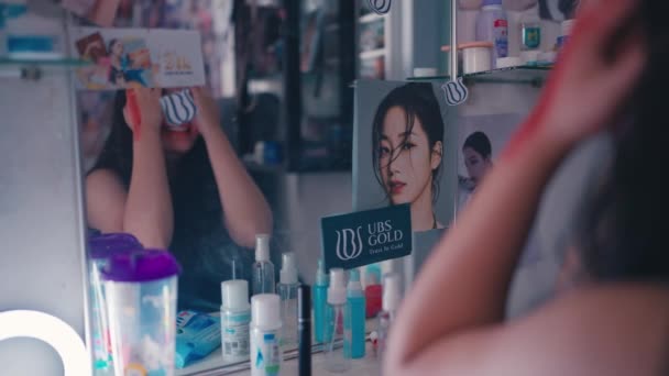 アジア系の女が怒って化粧をして鏡の前にタントラを投げる — ストック動画