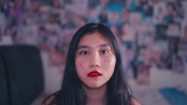 一个亚洲的孩子在她那张乱糟糟的脸上抹了妆 因为她的脸看上去不漂亮 而且在她的房间里 — 图库视频影像