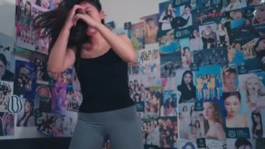 Asyalı bir kadın sabah odasında mutlu bir ifadeyle yatakta zıplıyor.