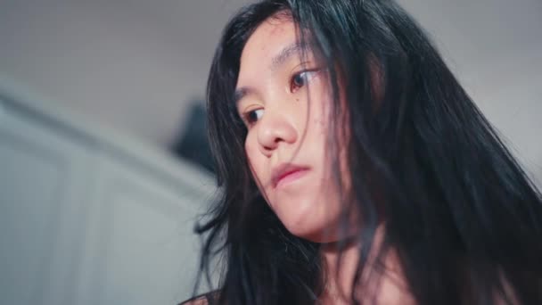 一个亚洲女人看起来很伤心 因为她对自己房间里丑陋的脸没有信心 — 图库视频影像