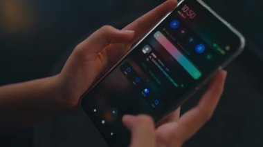Kafedeki arkadaşından gelen bir mesajı okurken elinde akıllı bir telefon tutan bir kadın.