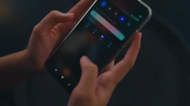 Kafedeki arkadaşından gelen bir mesajı okurken elinde akıllı bir telefon tutan bir kadın.