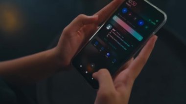 Kafedeki arkadaşından gelen bir mesajı okurken elinde akıllı bir telefon tutan bir kadın.