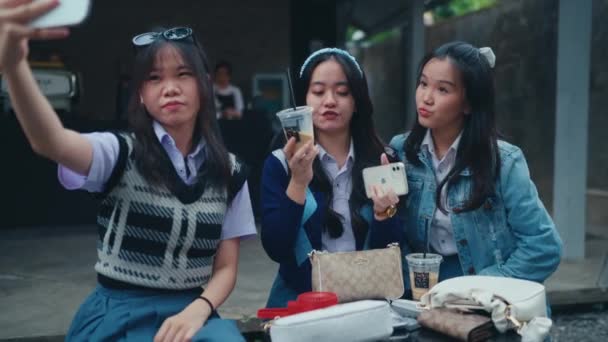 一群亚洲青少年和他们的朋友在咖啡店里用智能手机自拍 — 图库视频影像