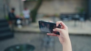 Kantinde bir grup kadının selfie 'sini çekerken akıllı bir telefonu tutmak.