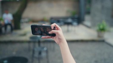 Kantinde bir grup kadının selfie 'sini çekerken akıllı bir telefonu tutmak.