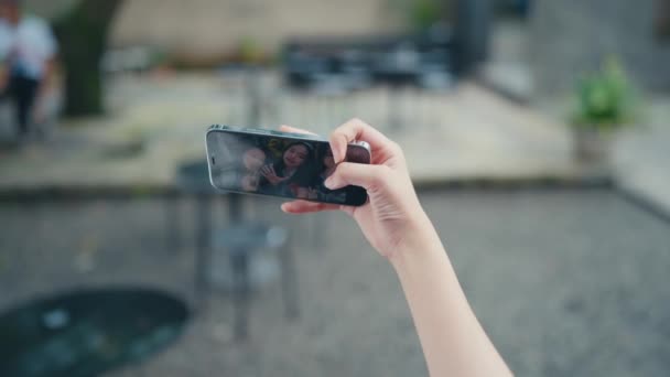 Mano Sosteniendo Teléfono Inteligente Mientras Toma Una Selfie Grupo Mujeres — Vídeos de Stock