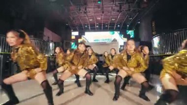Altın kostümlü bir grup dansçı bir gece kulübünde dans yarışmasına katılıyor.
