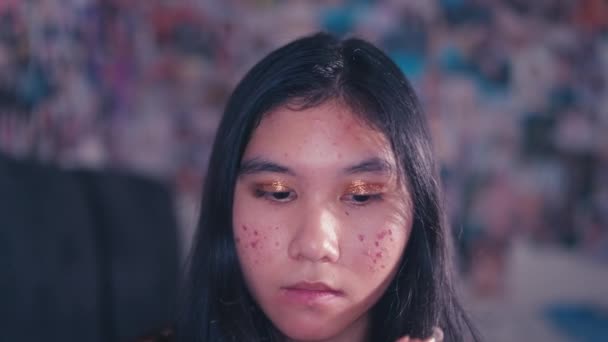 一个亚洲女孩在梳妆台前满脸粉刺时 脸上都是化妆品 — 图库视频影像