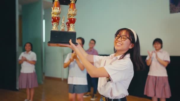在学校赢得竞赛后 一个高中生拿着奖杯 — 图库视频影像