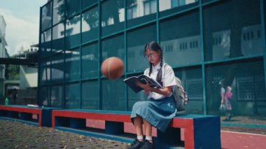 Bir kız öğrenciye basketbol topu çarptı ve basketbol sahasında otururken acıdan yere düştü.