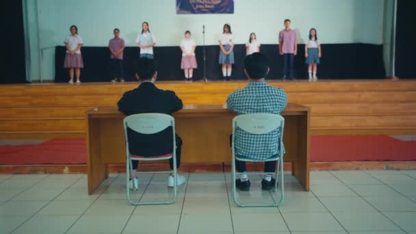 Bir Grup Öğrenci Okul Salonundaki Yargıçlardan Bir Duyuru Aldıklarında Sahnede — Stok video