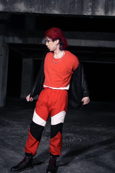 stock image an asian man with red hair and a black jacket is posing in an abandoned building at night