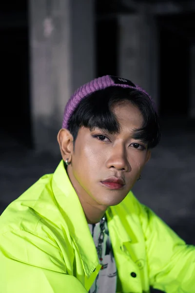 Азиатский Человек Зеленой Куртке Позирует Сидит Небрежно Заброшенном Здании — стоковое фото