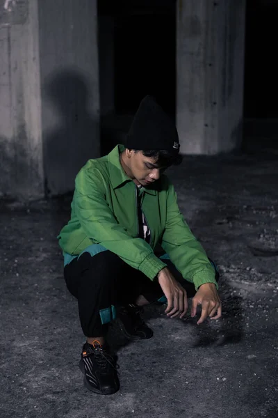 Homem Asiático Agachamentos Enquanto Vestindo Casaco Verde Edifício Assombrado — Fotografia de Stock