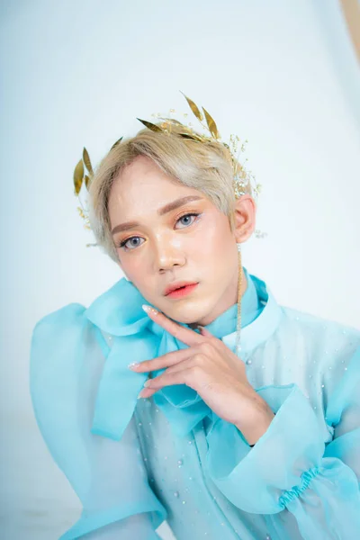 stock image a royal princess posing with a golden crown and blonde hair very cutely in a white room