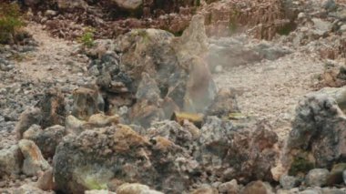 Yakın çekim, sülfürik, solmuş volkanik kayalar arasında yükselen fümerol bacasından yükselen sıcak buhar ve gazı yakalar. Bu klip aktif bir jeotermal bölgenin ham enerjisini ve termal enerjisini gösteriyor..