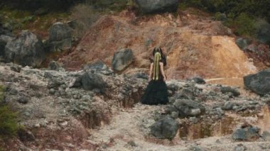 Yan taraftan, uzun örgülü siyah elbiseli bir kraliçe kayalık bir kanyonda yavaş ve zarif bir dans eder. Zarif hareketleri ve dramatik kostümü büyüleyici bir fantezi ve performans sahnesi yaratıyor..