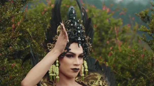 Ведьма Черном Платье Крыльями Танцует Страшным Выражением Перед Зеленым Кустом — стоковое видео