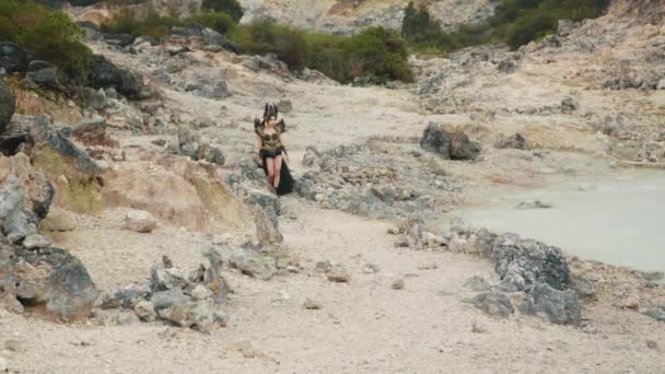 黒い衣装を着た魔女が山の中の石灰岩の谷を歩く — ストック動画