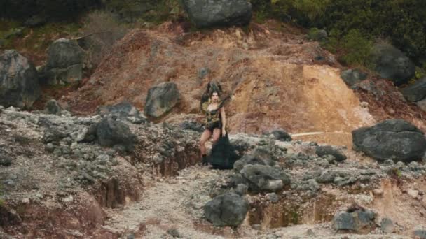 Una Bruja Vestido Negro Caminando Por Una Montaña Llena Rocas — Vídeo de stock