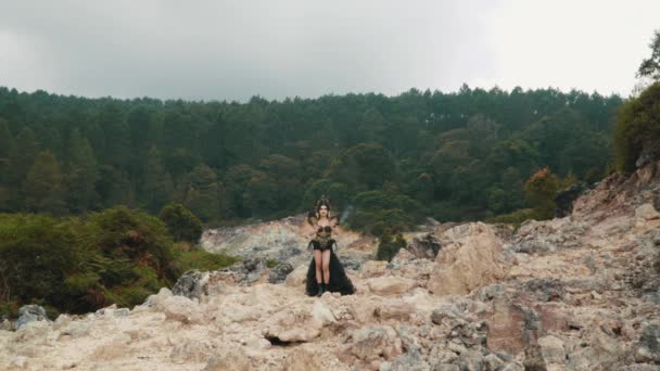 緑の木々と岩に囲まれた山間の谷で踊るゴシック少女 — ストック動画