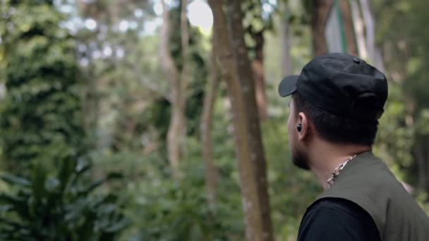 Siyah Şapkalı Asyalı Bir Adam Ormanın Ortasındaki Manzaranın Tadını Çıkarırken — Stok video