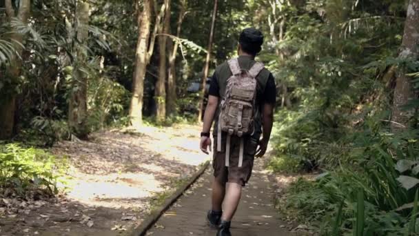 Een Aziatische Man Loopt Overdag Een Pad Een Bos — Stockvideo