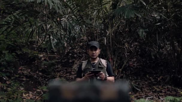Ένας Ασιάτης Ανοίγει Ένα Κουτί Θησαυρού Στη Μέση Ενός Δάσους — Αρχείο Βίντεο
