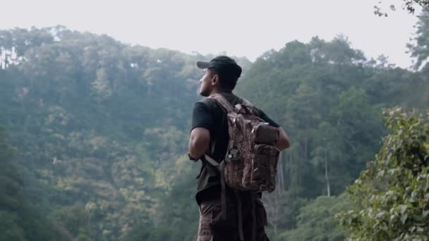 Азиатский Мужчина Стоящий Краю Скалы Глядя Красивые Природные Пейзажи Лесу — стоковое видео