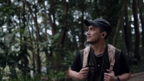 Ένας Ασιάτης Μαύρο Καπέλο Περπατάει Εξερευνώντας Ένα Δάσος Στα Βουνά — Αρχείο Βίντεο