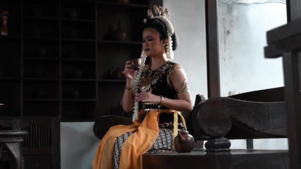 Javanese Nevěsta Pije Šálek Čaje Obývacím Pokoji Hnědou Dřevěnou Židlí — Stock video