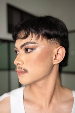 Yüzü ağır makyajlı, siyah kaşlı Asyalı bir adamın yüzünü bir odada gördüm.