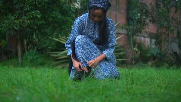 青いドレスを着て 緑の公園の草の上を歩いているアジア人女性 — ストック動画