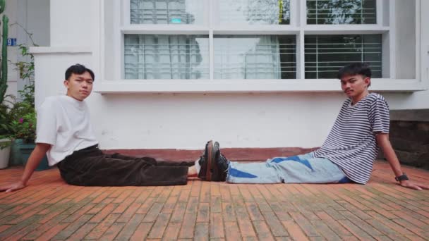 亚洲人和他的朋友一起坐在一个非常放松的房子的地板上 — 图库视频影像
