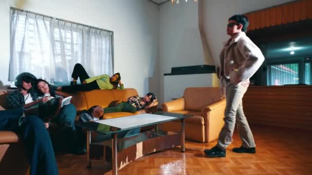 一个亚洲人走进客厅 和早上睡着的朋友坐在沙发上 — 图库视频影像