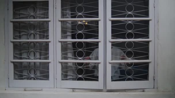 Asiatisk Man Öppnar Ett Vitt Fönster Fullt Järnstänger Medan Njuter — Stockvideo